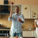 Attractive loving couple having fun in the kitchen. Handsome man juggle with apples to impress his girlfriend at home